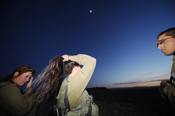 A female Israeli Defense Force (IDF) soldier combs her hair after a drill in a desert near Israel-Egypt border and Israeli Southern City of Sede Boker, on Dec 13, 2010.[Xinhua]