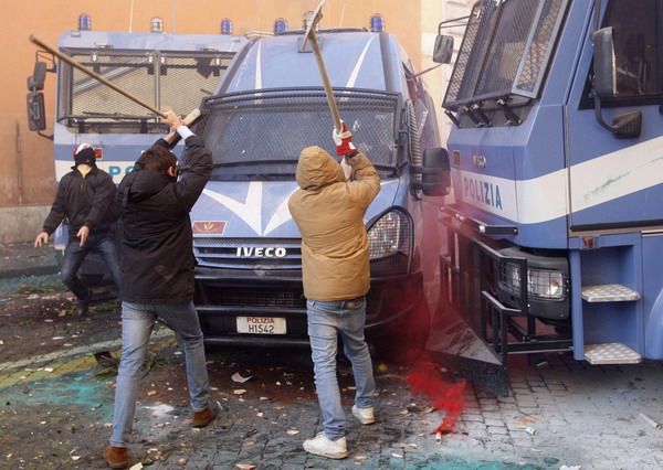 Demonstrators attack a police vehicle during anti-government clashes near the parliament building in Rome December 14, 2010. [China Daily/Agencies]