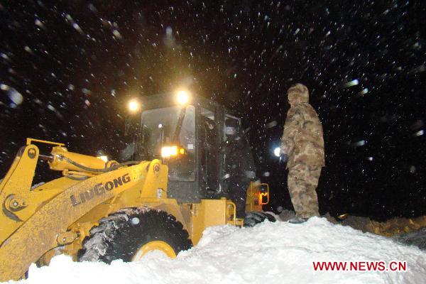 A bulldozer cleans the snow for stranded cars at the snow-covered national highway linking Jarud Qi and Holin Gol within north China&apos;s Inner Mongolia Autonomous Region, early on Dec. 15, 2010. More than 400 vehicles and an unknown number of people on board were stranded by snow on the national highway since Tuesday afternoon in Inner Mongolia. (Xinhua/Zhang Bodong) 