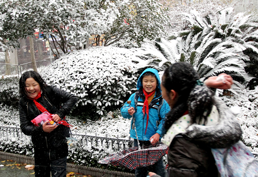 Children play with snow in east China&apos;s Shanghai, Dec. 15, 2010. Various parts of China, including Shanghai, embraced the first snow of this winter on Wednesday. A low temperature alarm has been issued by local meteorological department. [Xinhua]