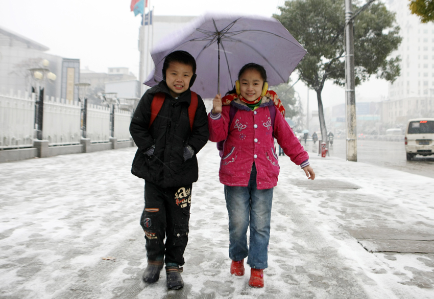 Pupils walk on a snow-covered road in Wuhan, capital of central China&apos;s Hubei province, Dec 15, 2010. The first large scope of snowfall of this winter hit Hubei Province from Tuesday night.[Photo/Xinhua] 