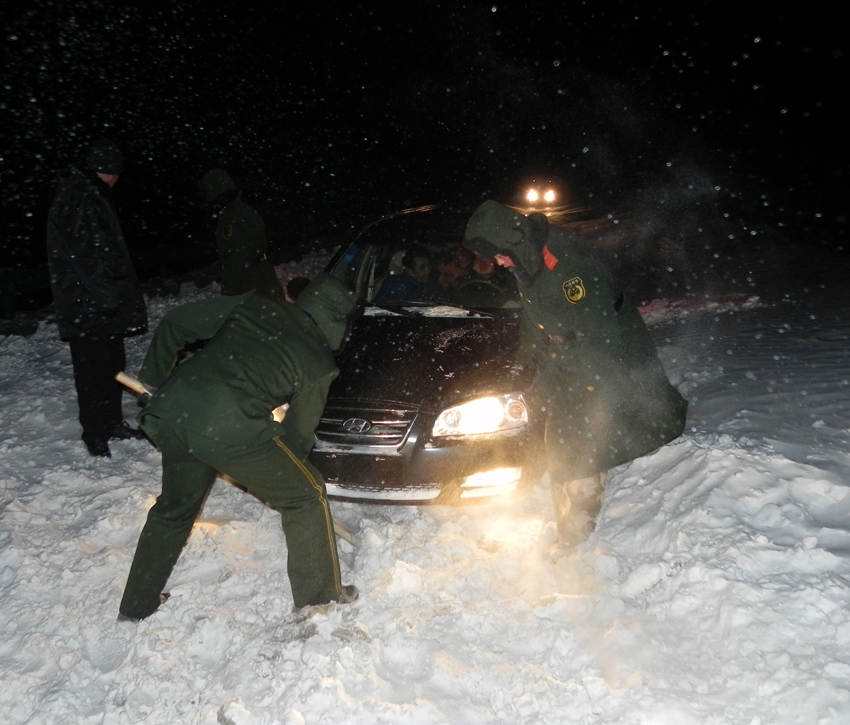 Rescuers clean the snow for a stranded car at a national highway linking Jarud Qi and Holin Gol within north China&apos;s Inner Mongolia autonomous region, early on Dec 15, 2010. More than 400 vehicles and an unknown number of people on board were stranded by snow on the national highway since Tuesday afternoon in Inner Mongolia.[Photo/Xinhua]