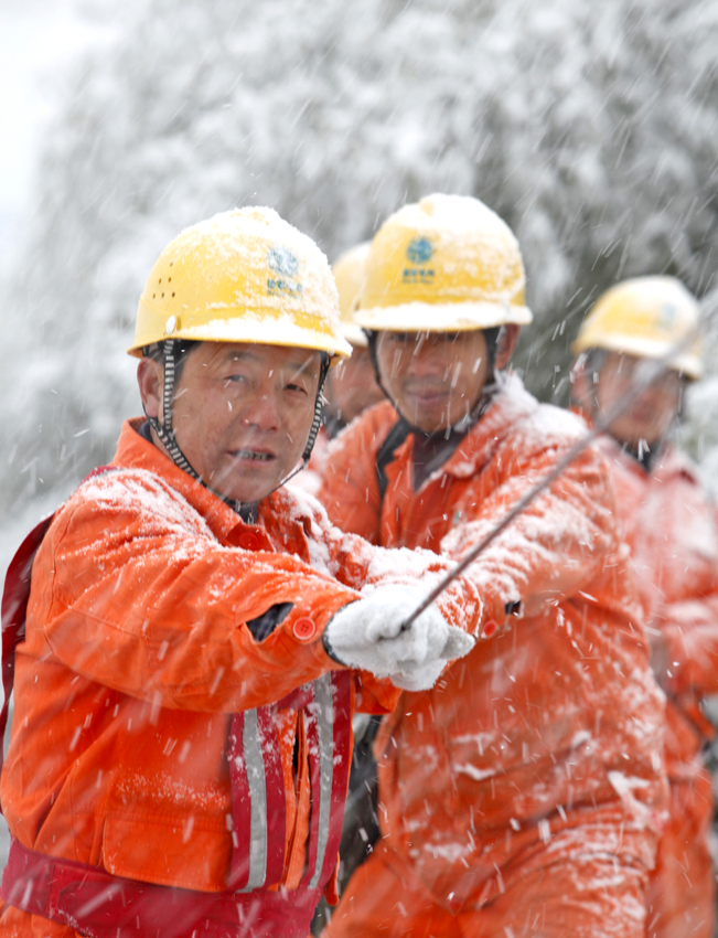 Electricians repair power lines in Ningguo, central China&apos;s Anhui province, Dec 15, 2010. Anhui Meteorological Bureau issued blue warning signal for snowstorm at 11:00 am Dec 15, 2010.[Photo/Xinhua]