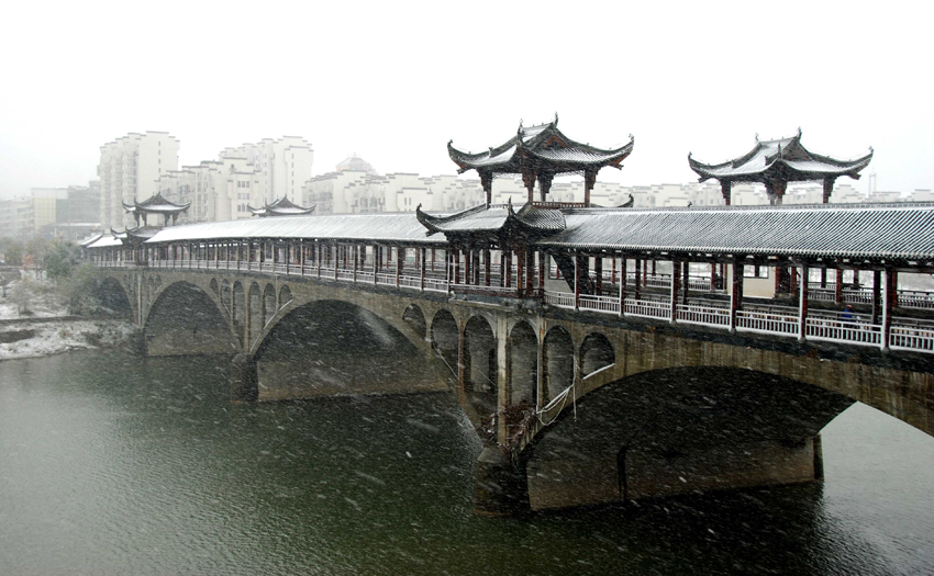 Photo taken on Dec 15, 2010 shows snow-covered bridge in Wuyuan, Xiangxi province. Wuyuan witnessed the first snow of this winter Wednesday morning.[Photo/Xinhua]