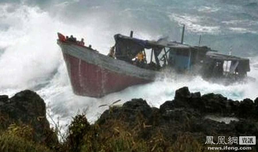 A boat laden with refugees is driven onto rocks at Christmas Island in this still image taken from video December 15, 2010.[news.ifeng.com]