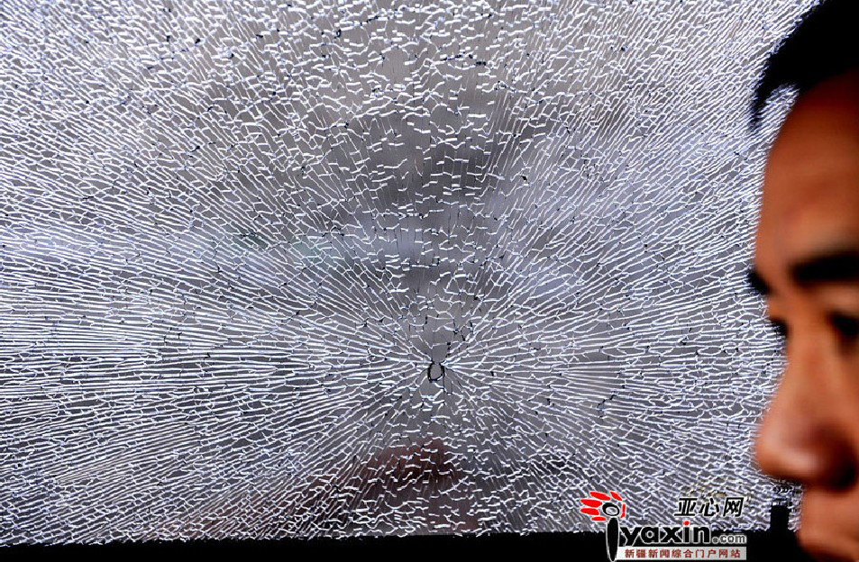 A driver is seen near a broken car glass after strong wind hits Urumqi Dec 15, 2010.[Yaxin.net]