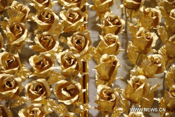 Photo taken on Dec. 15, 2010 shows golden roses made by foil of 99.99 percent gold at a gold store in Nanjing, capital of east China&apos;s Jiangsu Province. The price of the golden rose is 299 RMB yuan (45 US dollars) per item. [Xinhua] 