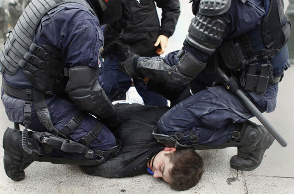 A protester is detained by the special &apos;Dias&apos; police unit during clashes in central Athens Dec 15, 2010. Police fired teargas at protesters who threw dozens of petrol bombs and burned several cars in the central Syntagma square outside parliament on Wednesday as Greek protests against government austerity measures escalated. [China Daily/Agencies]