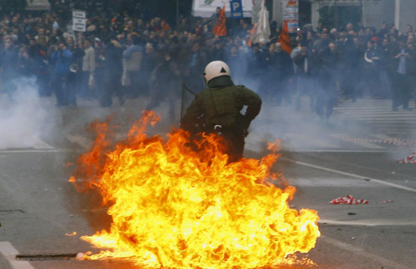 A riot policeman is engulfed in flames caused by a petrol bomb thrown by protesters during clashes in central Athens Dec 15, 2010. [China Daily/Agencies]