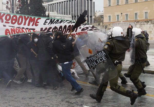 Riot policemen chase away protesters during clashes in central Athens Dec 15, 2010. [China Daily/Agencies] 