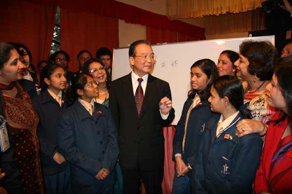 Premier Wen Jiabao talks with teachers and students at the Tagore International School in New Delhi on Wednesday during his three-day visit to India. [China Daily]