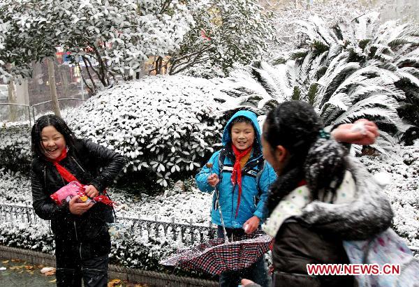 Children play with snow in east China&apos;s Shanghai, Dec. 15, 2010. Various parts of China, including Shanghai, embraced the first snow of this winter on Wednesday. A low temperature alarm has been issued by local meteorological department. 