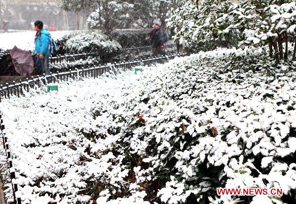 Children walk in snow in east China&apos;s Shanghai, Dec. 15, 2010. Various parts of China, including Shanghai, embraced the first snow of this winter on Wednesday. A low temperature alarm has been issued by local meteorological center. 