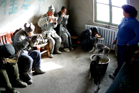 Mentally disabled workers have a meal break Saturday inside an illegal factory in Xinjiang. 