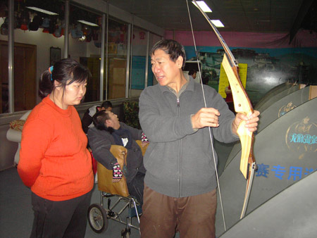 A mentally disabled woman learns how to shoot an arrow at an event held by Huiling Community Center for the Mentality Disabled. Photo: Huiling Community Center for the Mentality Disabled