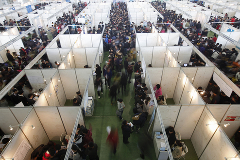 College graduates seek vacancies during a job fair in Changchun, Northeast China's Jilin province, in November. [File photo/China Daily]