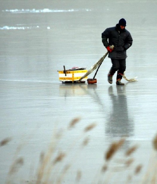 A man walks on the ice of a frozen river in Tianjin, Dec 15, 2010. [Xinhua]