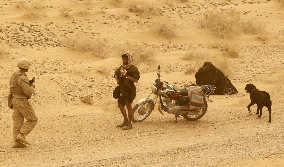 A U.S. marine from the 1st Light Armoured Reconnaissance Battalion, Jump Platoon checks a villager for a suicide bomb vest while on patrol near a sandstorm in a desert in Helmand, Afghanistan September 13, 2010. [China Daily] 