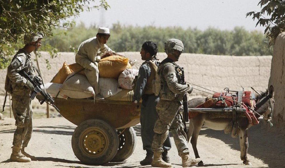 U.S. soldiers from 3rd Platoon, Bravo Company, 1-22 Infantry Battalion and an Afghan policeman conduct a check on a resident on a donkey drawn cart during patrol at a village in Kandahar province, southern Afghanistan, October 4, 2010. [China Daily]