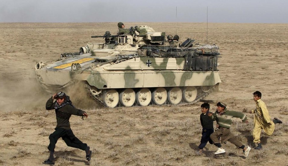  Afghan children run beside a Marder armoured personnel carrier (APC) of the German Bundeswehr armed forces with the 2nd armoured infantryman battalion 261 during a mission in Chahar Dara district in the outskirts of Kunduz, northern Afghanistan, December 16, 2010. [China Daily]