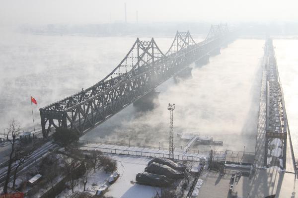 Photo taken on Dec. 16, 2010 shows the Sino-DPRK Friendship Bridge on the Yalu River which is vaguely seen in the winter fog in Dandong, a border city of northeast China&apos;s Liaoning Province. [Xinhua]