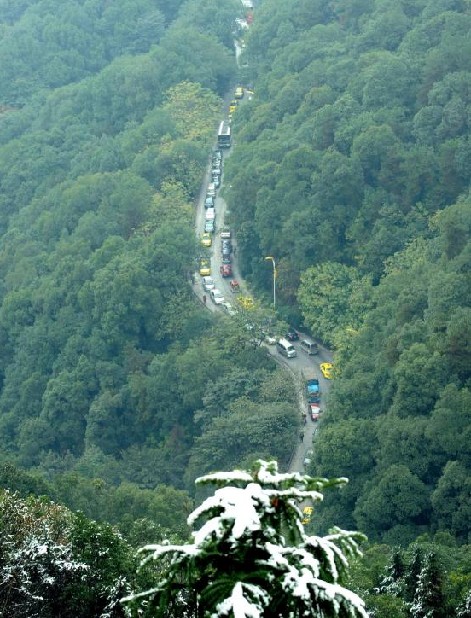 Vehicles line up on the road to the top of a snowy mountain in Chongqing, Dec 16, 2010. [Xinhua]