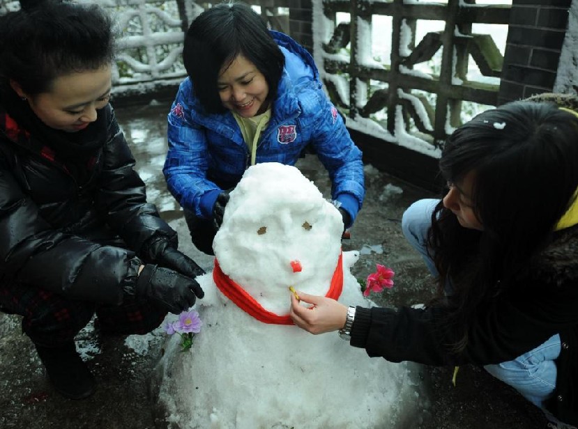 People play with snow in Chongqing, Dec 16, 2010. [Xinhua]