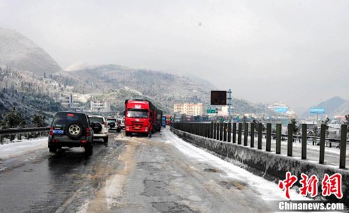 Trucks and cars drive slowly on the Beijing-Hong Kong-Macao Freeway in Shaoguan county, South China's Guangdong province, Dec 16, 2010. [Photo/Chinanews.com]