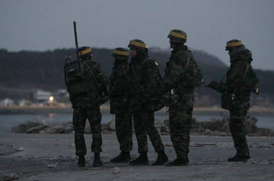 The Republic of Korea's marines patrol as residents board a ship to leave Yeonpyeong Island, at a port on the island December 17, 2010. [China Daily/Agencies] 