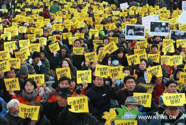 South Korean protestors hold banners and shout slogans during a anti-government rally in Seoul, capital of South Korea on Dec. 18, 2010. South Korea has declared plans for a live shell artillery drill in the waters southwest of Yeonpyeong Island on a selected date from Dec. 18-21 depending on weather conditions. 