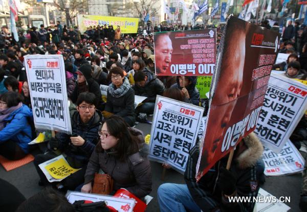 South Korean protestors hold banners and shout slogans during a anti-government rally in Seoul, capital of South Korea on Dec. 18, 2010. South Korea has declared plans for a live shell artillery drill in the waters southwest of Yeonpyeong Island on a selected date from Dec. 18-21 depending on weather conditions.