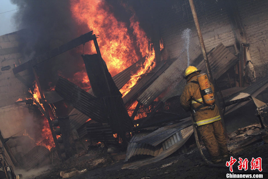 A firefighter tries to put out a fire at the area of an explosion of a Pemex pipeline in the village of San Martin Texmelucan near Puebla Dec 19, 2010. [photo/chinanews.com]