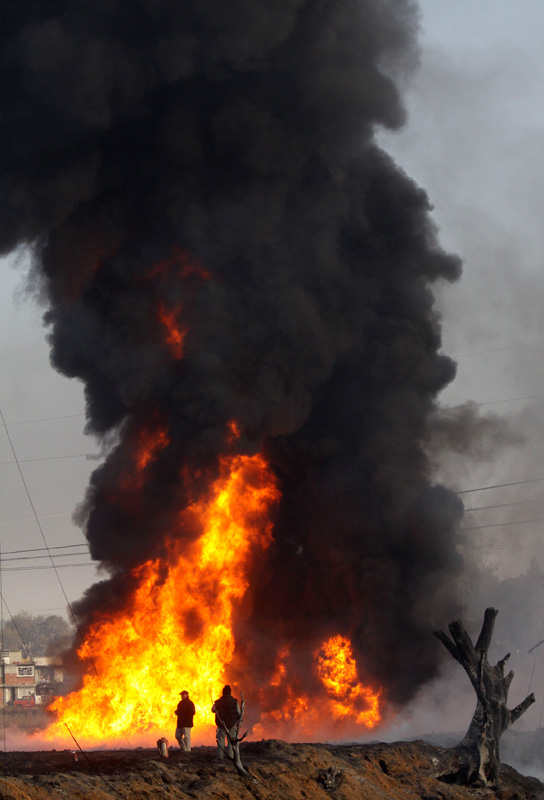 Fuel thieves tampering with an oil pipeline could have sparked a deadly blast in central Mexico that flooded streets with fire and killed at least 27 people before dawn on Sunday, Dec. 19, 2010.[photo/Xinhua] 