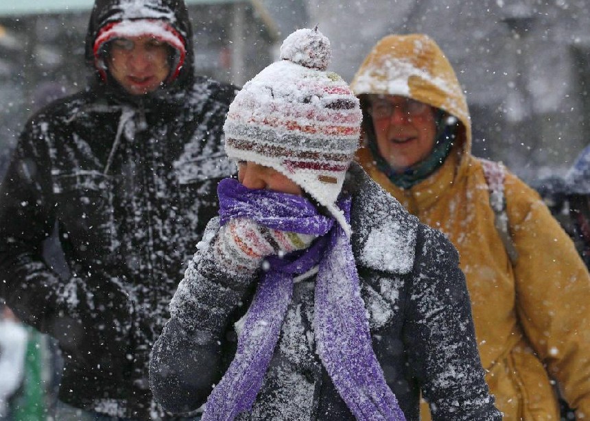 A woman covers her face as she walks in snow in Edinburgh, Scotland Dec 19, 2010. Britons Sunday faced little respite from the Arctic conditions that have disrupted travel and shopping plans on the last weekend before Christmas, normally one of the busiest times of the year. [China Daily/Agencies]