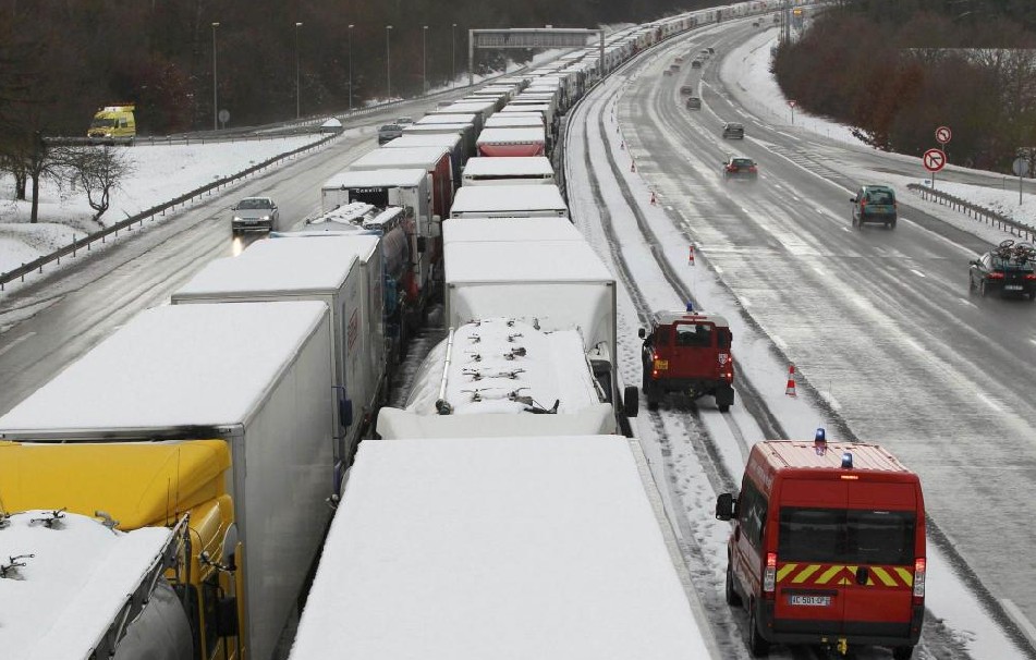 Security vehicles drive past trucks forming a queue on the Paris to Bordeaux motorway at Saint-Arnoult-en-Yvelines, after authorities halted lorry traffic during a snowfall which hit the Paris region, Dec 19, 2010. Snow blanketed northern France, delaying trains and forcing flights to be cancelled. [China Daily/Agencies]