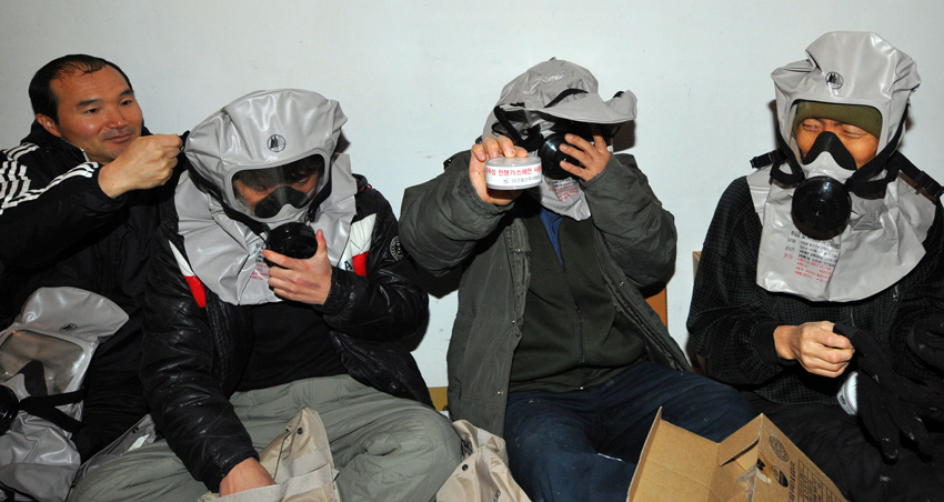 South Korean residents wear gas masks after taking shelter on Yeonpyeong Island, South Korea, December 20, 2010. [Xinhua]