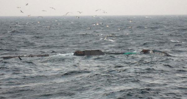 A Chinese trawler (C) capsizes after a collision with an ROK Coast Guard ship in the early afternoon of Dec 18. [Photo/Agencies]