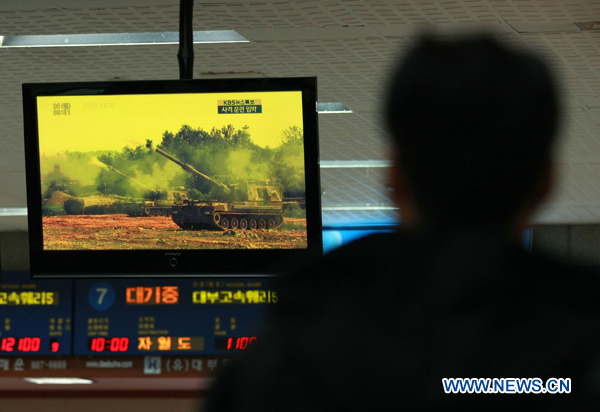 A South Korean watches TV broadcasting Yeonpyeong Island at the port of Incheon in Gyeonggi province of South Korea on Dec. 20, 2010. [Park Jin Hee/Xinhua]