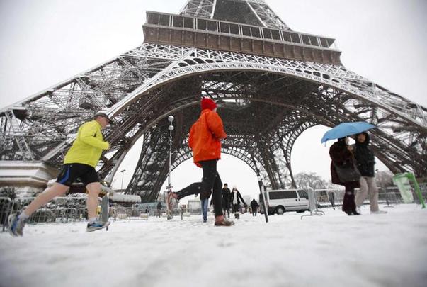 Joggers pass the Eiffel Tower during a heavy snowfall in Paris Dec 19, 2010.