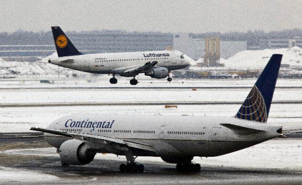 A Lufthansa airplane (top) lands as a Continental airplane waits for clearance to take off at the airport of Frankfurt/Main on December 20, 2010 in Frankfurt/Main, central Germany. Authorities cancelled about 300 flights at Germany&apos;s main airport at Frankfurt on early December 20, 2010, and expected more snow, an airport spokeswoman said, a day after hundreds of other flights were scrapped. [Xinhua]