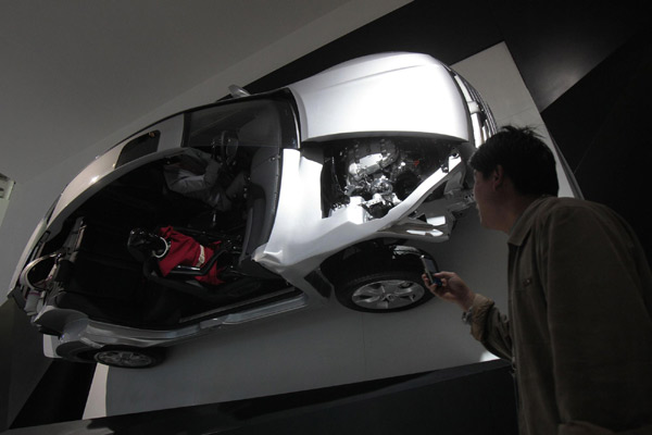 A visitor takes a picture of a mock-up of a Honda Crosstour at the Guangzhou Autoshow Dec 20, 2010. [Agencies]