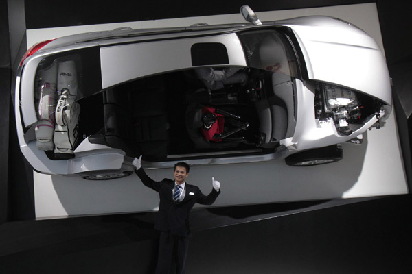 A worker poses with a mock-up of a Honda Crosstour at the Guangzhou Autoshow Dec 20, 2010. [Agencies] 