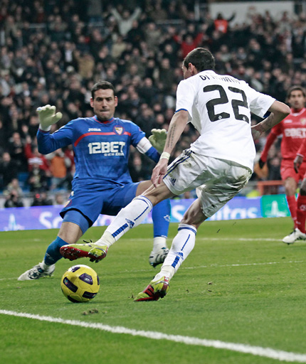 Real Madrid's Angel Di Maria (right) is on the ball seconds before scoring past Sevilla goalkeeper Andres Palop during their Spanish league match at Santiago Bernabeu Stadium in Madrid on Sunday.