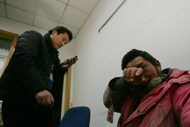 Mentally disabled Liu Xiaoping is seen with his brother at a police station on December 19, 2010 in Gaoling county, Shaanxi Province of China. Liu was rescued by policemen from a illegal factory in Toksun county of Northwestern China&apos;s Xinjiang Uygur Autonomous Region. [Agencies]