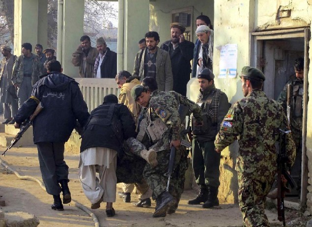 A wounded Afghan soldier is carried away by his comrades during a gunbattle with suicide bombers in Kunduz province Dec 19, 2010. Three Afghan soldiers and two policemen were killed in an attack by at least three suicide bombers on an army recruitment centre in the northern city of Kunduz, the city&apos;s police chief said. The Defence Ministry said four bombers attacked the centre and that two had been killed and the remaining two were trapped inside. [China Daily/Agencies]