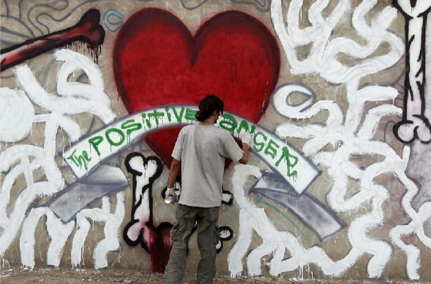 An Afghan artist paints graffiti on the wall of an industrial park in Kabul Dec 19, 2010. [China Daily/Agencies]