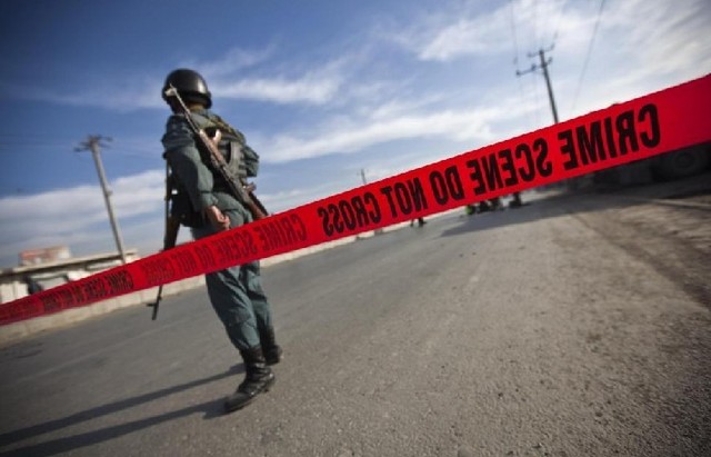 An Afghan policeman keeps watch after a suicide attack in Kabul Dec 19, 2010. Five Afghan army training officers were killed and nine wounded in an attack by two Taliban suicide bombers in Kabul on Sunday, the Defence Ministry said. [China Daily/Agencies]