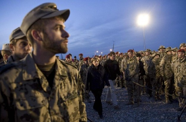  German Chancellor Angela Merkel and Defence Minister Karl-Theodor zu Guttenberg (centre, R) walk among German soldiers to take part in a commemoration ceremony for their comrade killed on Dec 17, at the German army Bundeswehr field camp Marmal in Mazar-e-Sharif, north of Kabul, Dec 18, 2010. German Chancellor Angela Merkel who is visiting the German troops with the International Security Assistance Force (ISAF) in Afghanistan, also attended the ceremony. [China Daily/Agencies]