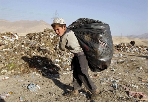 A boy carries rubbish for recycling outside Kabul Dec 15, 2010. About 1.2 million Afghan children carry out part or full time work, the government says, in a country where war, poverty, widespread unemployment and a preference for large families have created a huge underage labour market. [China Daily/Agencies]