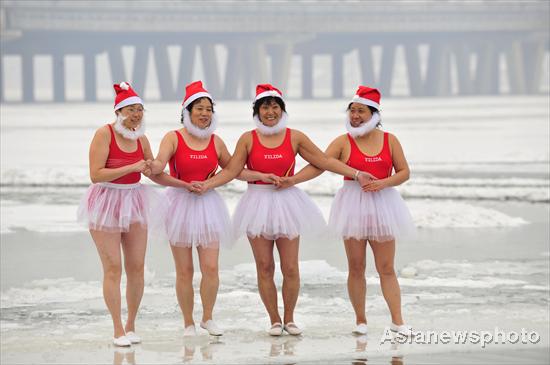 People dressed like Santa Claus play on the icy Hunhe River in Shenyang, Northeast China's Liaoning province, Dec 20, 2010. While most people were staying inside to keep warm as a cold snap swept North China, some found fun outdoors in the chill. [Photo/Asianewsphoto] 
